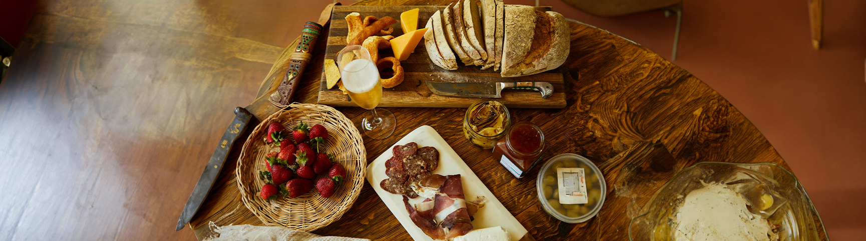 Table with selection of breads, meats, chutney's and other accompaniments for cheese 
