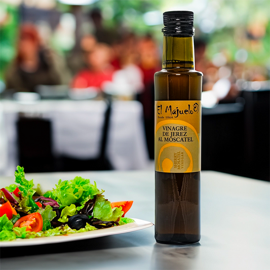 a lifestyle image of the El Majuelo oil in a restaurant, the bottle in the image is next to a salad 