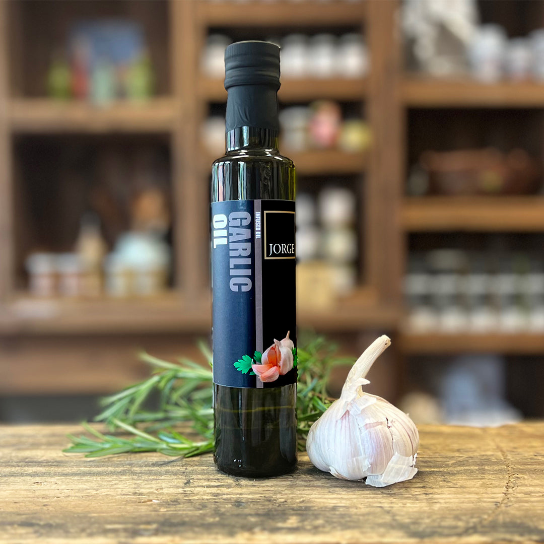 Garlic bottle in a lifestyle setting in farm shop . Garlic bottle with a garlic bulb and sprig of rosemary 