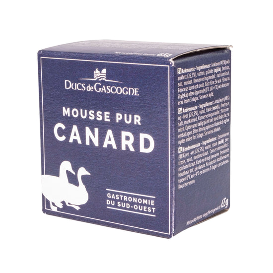 A blue cardboard box featuring two ducks. The label reads "Ducs de Gascogne Mousse Pur Canard Gastronomie du Sud-Ouest" in French, which translates to "Dukes of Gascony: Pure Duck Mousse Gastronomy of the Southwest." 